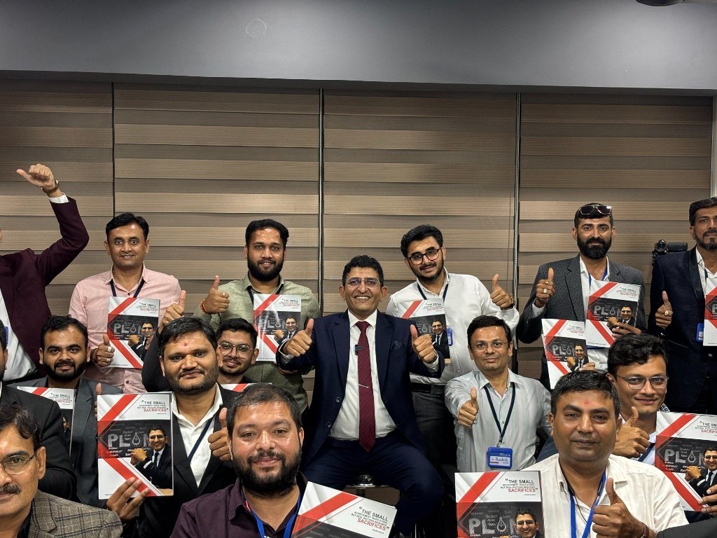 Shakil Kadva with business owners holding their Business Discovery books
